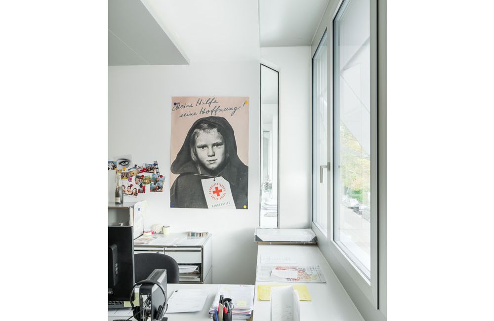 Büroarbeitsplatz mit Sicht auf ein Poster des Schweizerischen Roten Kreuz